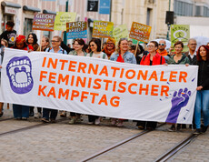 Eine Gruppe von Frauen und an ein paar Männer bildet die Spitze des Demonstrationszugs am Weltfrauentag 2026 in Linz. Sie hält ein Banner in Händen, auf dem steht: Internationaler Feministischer Kampftag.