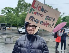 Ein junger Mann mit einem Schild bei der Baustelle Inklusion vor dem Parlament in Wien 2025.