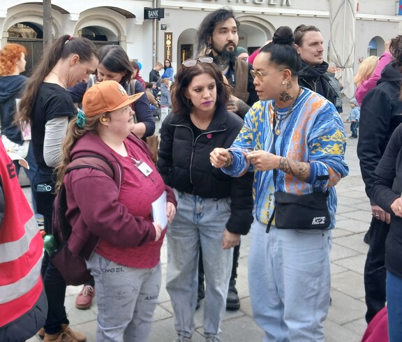 Demonstranten und Demonstrantinnen reden miteinander bei der Demo zum Weltfrauentag in Linz 2026.
