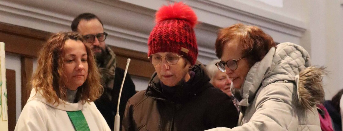 Drei Personen am Rednerpult. 