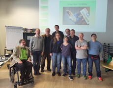 Ein Gruppe an Personen steht beisammen und schaut in die Kamera. 