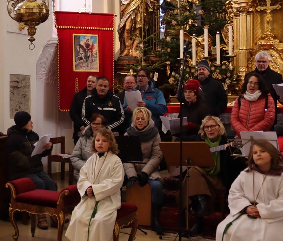 Vier Ministranten und der Chor in einer Kirche