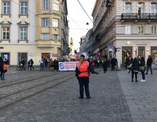 Viele Personen strömen auf einen großen öffentlichen Platz und trageb dabei Plakate.