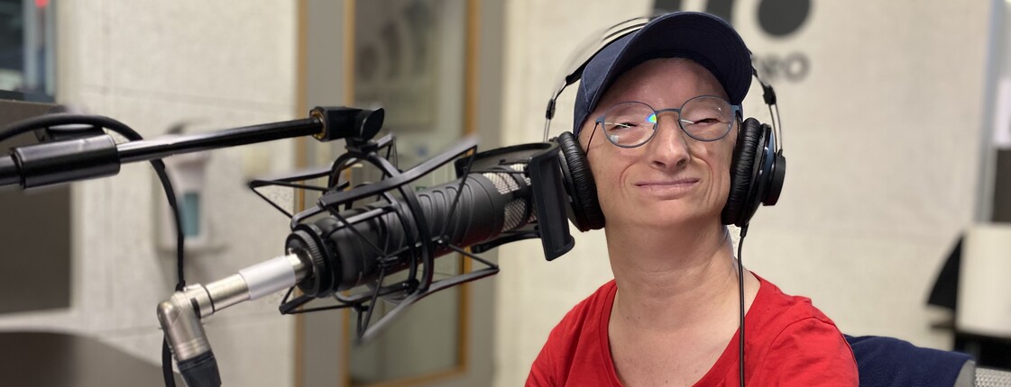 Sabine Nemmer im Tonstudio mit Mikrofon und Kopfhörern.