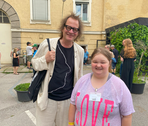 Ein Mann und eine Frau stehen vor einem Gebäude. 