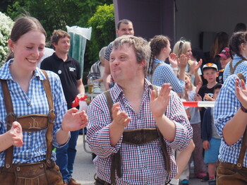 Zwei Männer und eine Frau tanzen in der Lederhosen