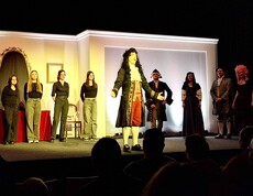 Ein Sprecher im Kostüm - mehrere Personen auf der Bühne