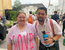 Ein Mann und eine Frau stehen nebeneinander und lachen in die Kamera. 