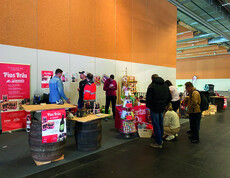 Mehrere Personen stehen auf einen Messestand und infomieren sich. 