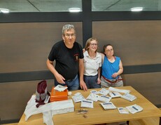 3 Personen an einem Tisch mit Materialien 
