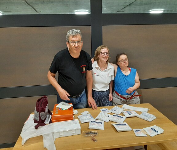 3 Personen an einem Tisch mit Materialien 