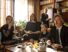 Familie sitzt mit Großeltern an einem Tisch