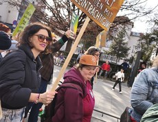 Zwei Demonstrantinnen tragen beim Feministischen Kampftag 2026 in Linz ein Schild, auf dem steht: Stoppt Gewalt an Frauen mit Beeinträchtigung"