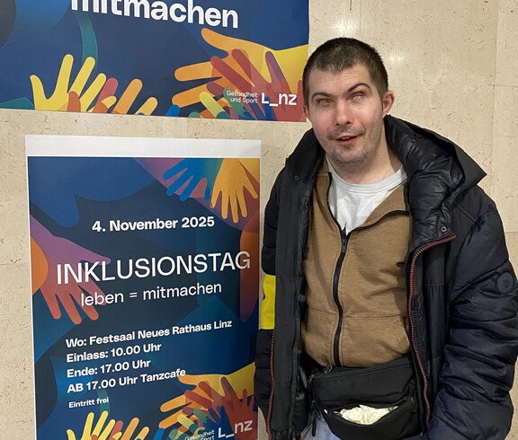 Benjamin vor dem Plakat des Inklusionstages 2025