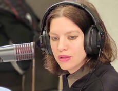 Frau mit Kopfhöhrer vor Mikro