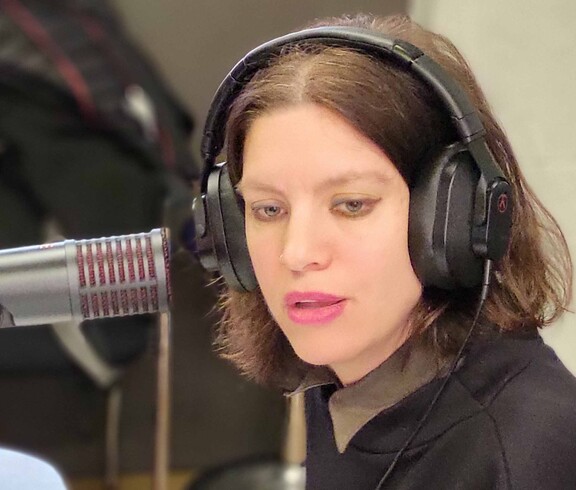 Frau mit Kopfhöhrer vor Mikro